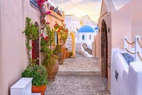 Étroite rue pittoresque d'Oia Village sur l'île de Santorin au coucher du soleil, Grèce.